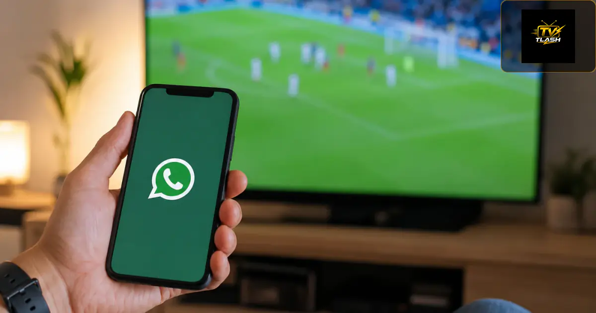 WhatsApp Support am Smartphone, funktionierender Fernseher im Hintergrund